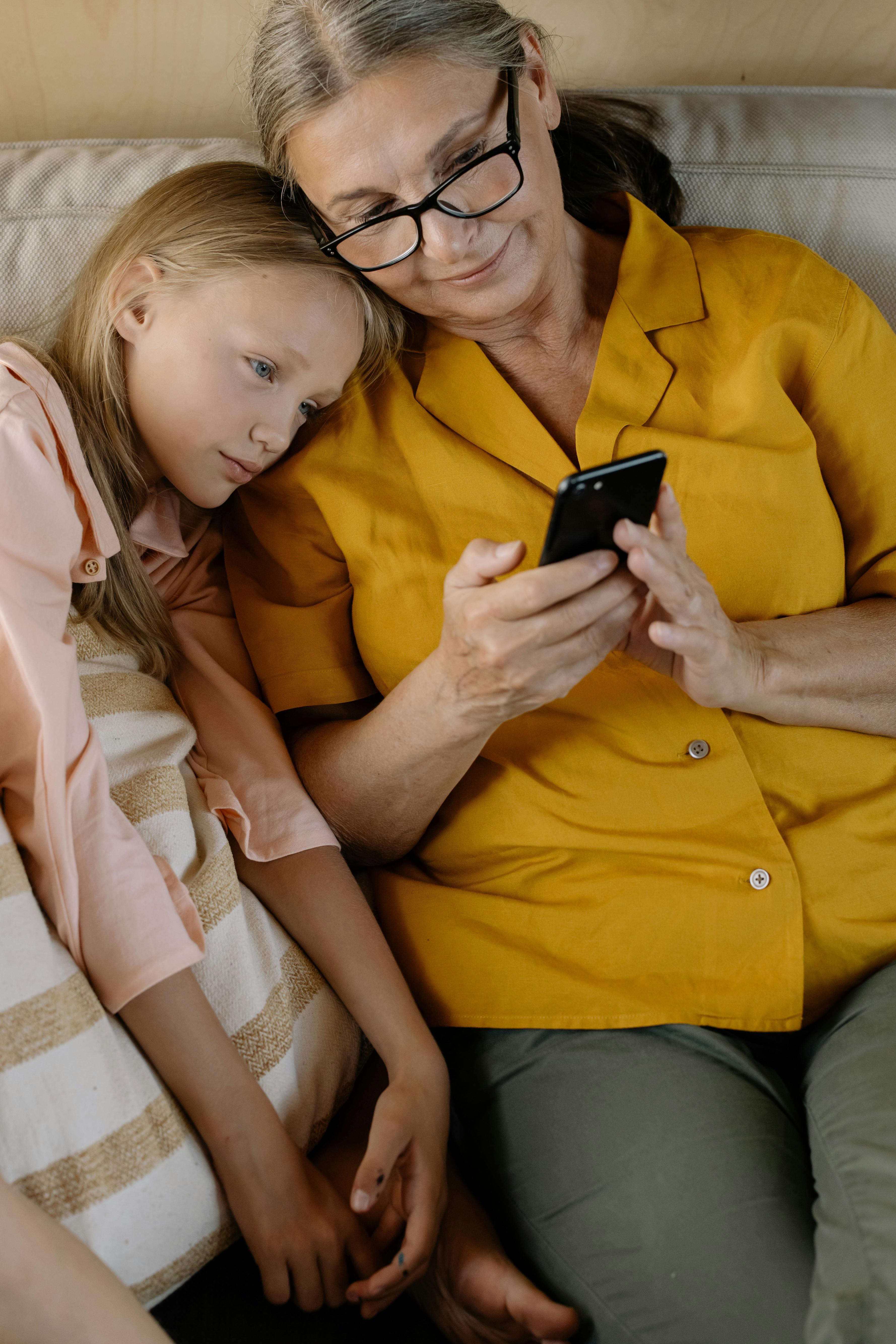 Grandmother and granddaughter looking at phone together